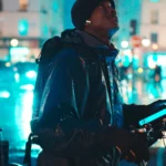 Souleymane avec son vélo de livraison dans une rue de Paris la nuit