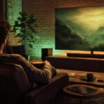 Spectateur installé devant un grand écran dans une ambiance verte et dorée