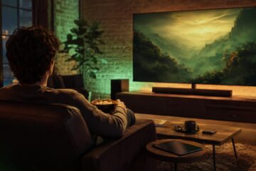 Spectateur installé devant un grand écran dans une ambiance verte et dorée