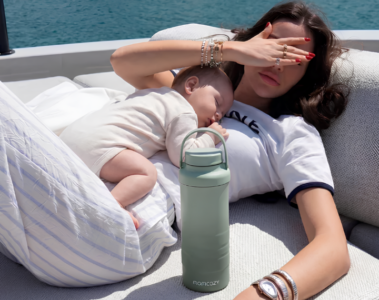 Mère allongée avec son bébé et un chauffe-biberon portable