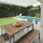12534517 – modern suburban backyard with table setting and swimming pool