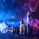 E-cigarette liquids.Vape.Accessories for Smoking. Electronic devices for Smoking.Smoking gadgets.Electronic cigarette and liquid bottles. Kit for vaping on a blue-purple background. Cigarette smoke