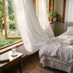 Chambre avec fenetre ouverte, rideaux blancs legers, draps en lin, verre d'eau, atmosphere fraiche matinale, illustration dormir canicule