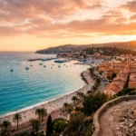 Vue panoramique de la Cote d Azur au coucher de soleil, baie de Nice avec palmiers et plage