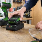 Bricoleur vérifiant une batterie dont le chargeur clignote rouge et vert.