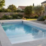 Choisir une piscine coque : 7 critères pour trouver le bon modèle Piscine coque rectangulaire avec plage immergée et volet dans un jardin