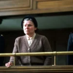 Vera Drake encadrée par deux policières au tribunal dans le film