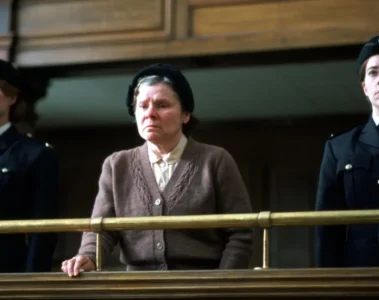 Vera Drake encadrée par deux policières au tribunal dans le film