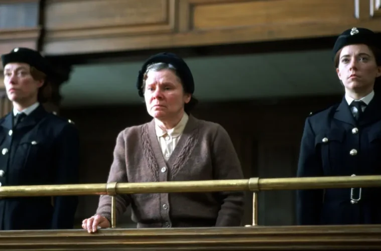 Vera Drake encadrée par deux policières au tribunal dans le film