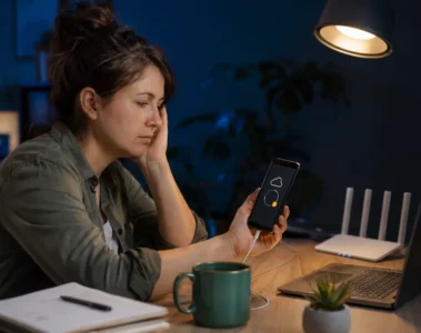 Femme attendant la fin d’une sauvegarde de téléphone bloquée dans son bureau.