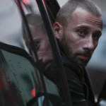Manuel près d’une voiture dans le film Frères ennemis