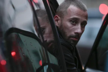Manuel près d’une voiture dans le film Frères ennemis
