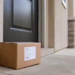 Colis neutre déposé devant une porte sans destinataire visible