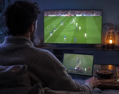 Un spectateur suit du rugby sur un ordinateur portable et une télévision