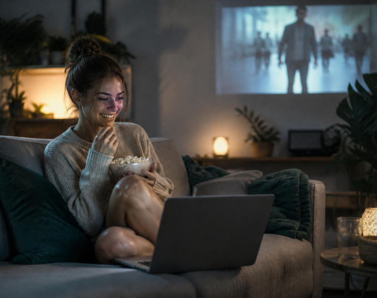Jeune femme regardant un film sur un ordinateur portable avec du popcorn