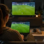 Une spectatrice regarde du football sur un ordinateur portable