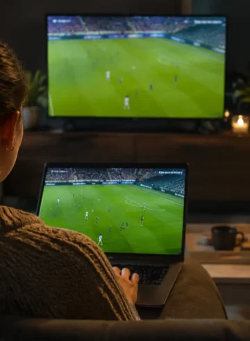 Une spectatrice regarde du football sur un ordinateur portable