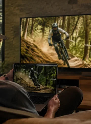 Un spectateur regarde une descente de VTT sur un ordinateur et une télévision