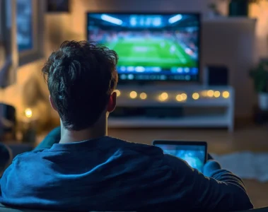 Un spectateur regarde un match de football à la télévision