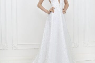 Modèle portant une robe de mariée blanche à fines bretelles et longue traîne