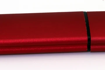 Clé USB rouge et noire photographiée sur fond blanc