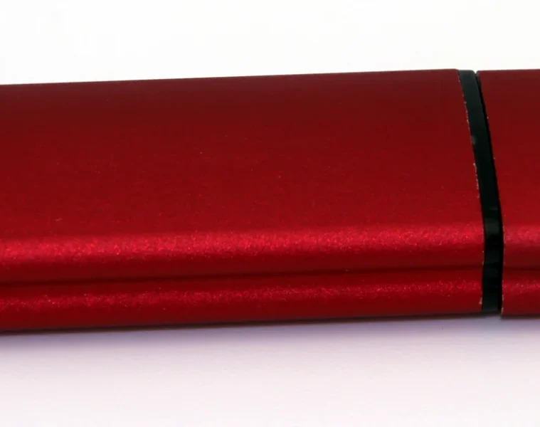 Clé USB rouge et noire photographiée sur fond blanc