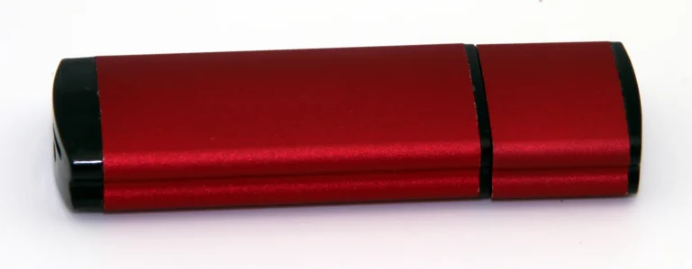 Clé USB rouge et noire photographiée sur fond blanc