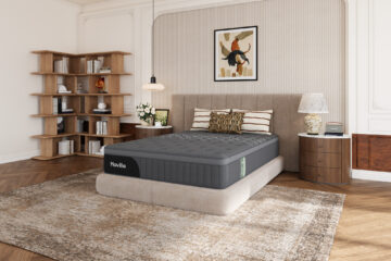 Matelas hybride Novilla AiryFlow gris installé sur un sommier dans une chambre aux tons beige et bois. Visuel produit fourni par Novilla dans le brief, page 3.